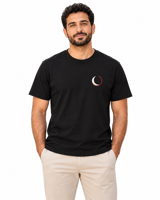 Black Moon Minimalist Soft Tee in Black — studio lifestyle front view — smaller crest